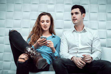 cinematic tone of young Caucasian man and woman talking together on sofa in the white room