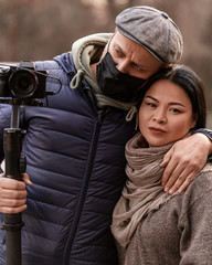Fototapeta premium Man photographer with camera street portrait. Casual couple street style. Outdoors lifestyle. Journalist in medical mask. Operator. Hipster stylish male. Creative hobie. Attractive trendy woman