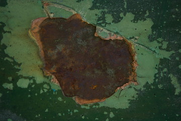 nieregularna powierzchnia o różnorodnych plamach w odcieniach zieleni błękitu oraz rdzawego brązu © Joanna