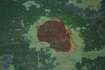 nieregularna powierzchnia o różnorodnych plamach w odcieniach zieleni błękitu oraz rdzawego brązu