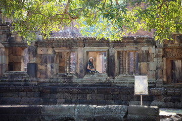 The woman is at the window of the Prasat Mueang Tam (Mueang Tam castle) in Buriram, Thailand