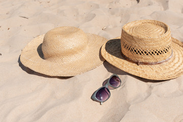 View of sandy beach with summer hats and sunglasses. Blank advertisement or packaging layout.