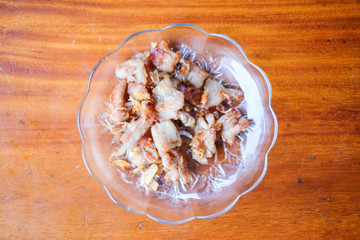 The garlic fried pork serve on white dish set on brown table - homemade food concept.