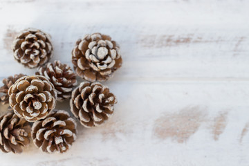 Fototapeta na wymiar Dried pine balls on a white vintage wooden