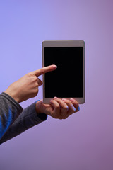 Close-up of human's hands with smartphone and black screen on purple background