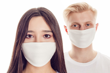 Couple of young people in protective face masks isolated on white.