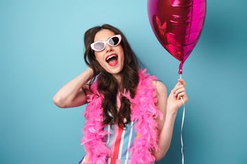 Photo of delighted young woman posing with balloon at camera