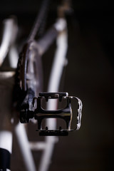 Fototapeta na wymiar Black metal pedal on a bike with hard light. Bike accessories
