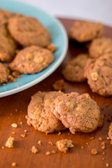 Delicious crunchy homemade chocolate cookies with walnut chunk on top of wooden table and white background.