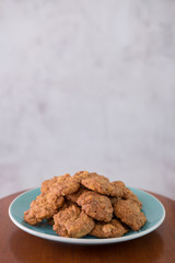 Delicious crunchy homemade chocolate cookies with walnut chunk on top of wooden table and white background.