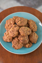 Delicious crunchy homemade chocolate cookies with walnut chunk on top of wooden table and white background.