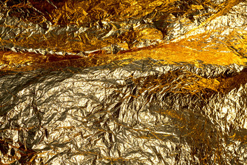 Texture of a thin crumpled sheet of foil. Crumpled foil background. Stock photo foil. Gold chrome...