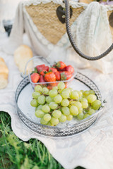 picnic in the park with beautiful food: strawberries, grapes, croissants