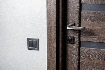 Two-key switch of gray color near the door, plastic mechanical switch. The light switch is installed after repair. Energy saving concept. Close up light switch