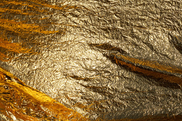Texture of a thin crumpled sheet of foil. Crumpled foil background. Stock photo foil. Gold chrome...