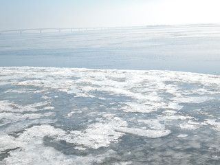 Winter nature background with blocks of ice on frozen water in spring
