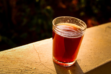 Outdoor Tea pouring into glass cup transparent with day sunlight.
