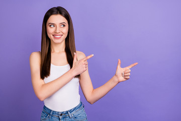 Portrait of positive cheerful girl promoter point index finger copyspace demonstrate ads promo recommend suggest select wear modern clothes isolated over violet color background