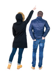 Back view of two pointing girl in winter jacket.