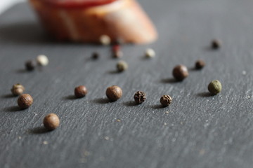 assorted peppers black white sweet on a black gray stone or table with a place to insert text