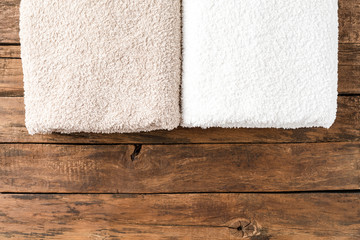 Overhead shot of clean folded towels on rustic wooden table with copyspace