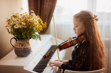 Home lesson for playing the violin and piano. The idea of activities for children during...