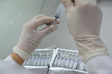 Almaty / Kazakhstan - 03.29.2019 : The fence of the medical solution from the vials into a syringe for analysis