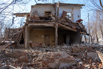 dismantling of an old building, a building without a wall and a roof with a rickety second floor, a bunch of bricks and rubbish