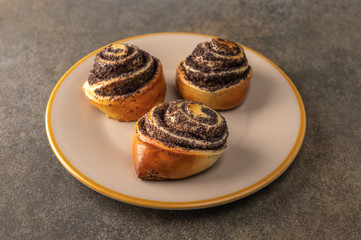 Homemade sweet buns with poppy seed on dark background