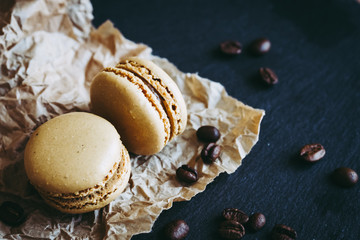 Deux macarons au café et grains de café sur une table en bois