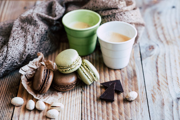 Macarons pistache et chocolat sur une table en bois