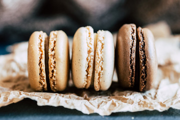 Trois macarons au gout vanille chocolat café sur un fond naturel