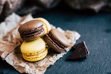 Macarons parfum citron et chocolat posés sur un fond ardoise