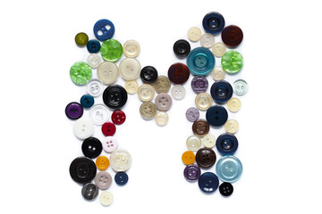 Letter M design made from clothing elements.