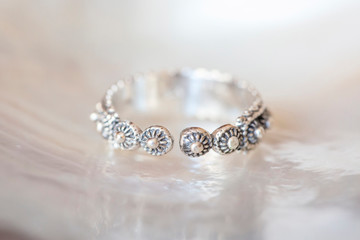 Sterling silver elegant ring in decorative shape on natural white shell background