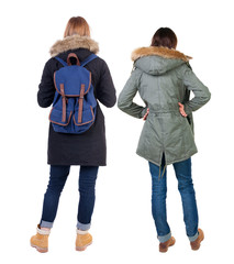 Back view of two young woman in winter jackets.