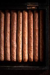 Top view of cigars in old wooden humidor