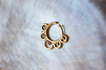 Brass metal nose decorative septum oriental boho jewelry on natural white shell background