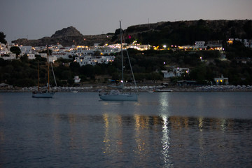Lindos Village in Rhodes, Greece. Panorama made from the sea at night.