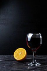 Glass with sangria and orange on a black background