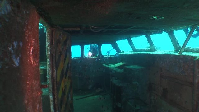 scuba divers exploring the ship wreck underwater ocean scenery of shipwreck
