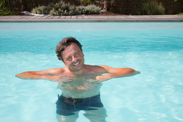 handsome guy half-naked cheerful man smiling laughing in blue water swimming pool