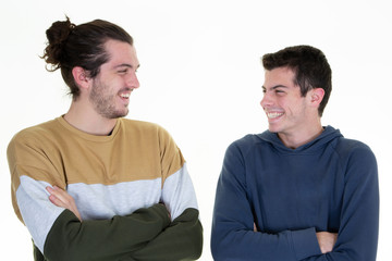 Fototapeta na wymiar Two handsome men arms crossed smiling and looking together each other isolated over white background