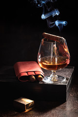 Cognac and smoking cigar on old humidor