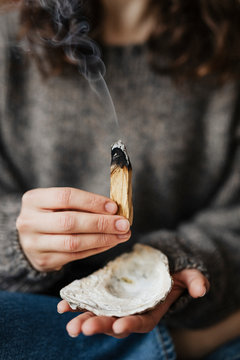 Woman buring palo santo for cleansing her home