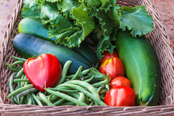 Fresh ripe vegetables in old wicker basket