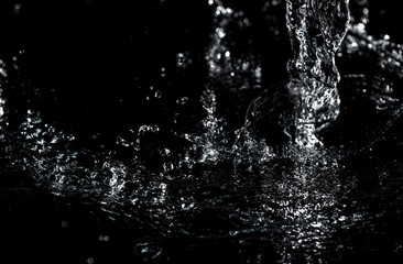 Splashes and drops of water are on a black background.