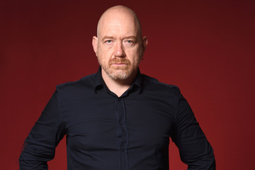 portriat of serious bald man on red background