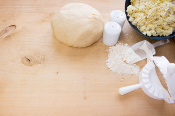 National Russian cuisine. Pierogi or pyrohy, vareniki, served with cottage cheese and potatoes on board.  Raw dumplings made of dough in handmade flour