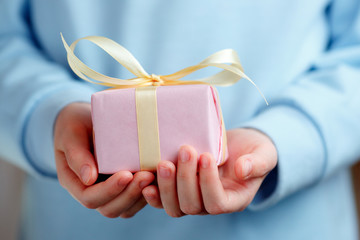 Child Holding a Gift Box On a Blue Background